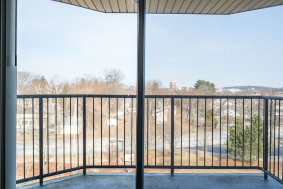 a balcony with a view of a city and a glass door at Carisbrooke at Manchester Apartments, Manchester, NH
