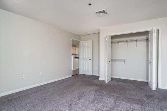 an empty bedroom with a closet and a door to the bathroom at Carisbrooke at Manchester Apartments, Manchester