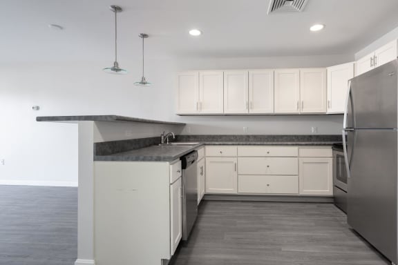 a kitchen with white cabinets and stainless steel appliances at Carisbrooke at Manchester Apartments, New Hampshire