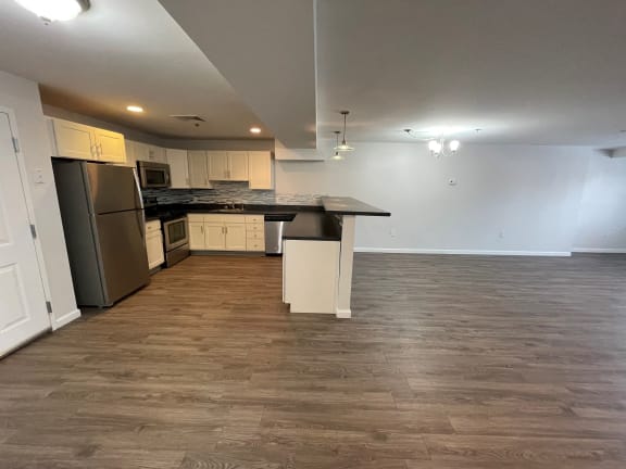 an empty living room and kitchen with a wood floor at Carisbrooke at Manchester Apartments, Manchester, New Hampshire