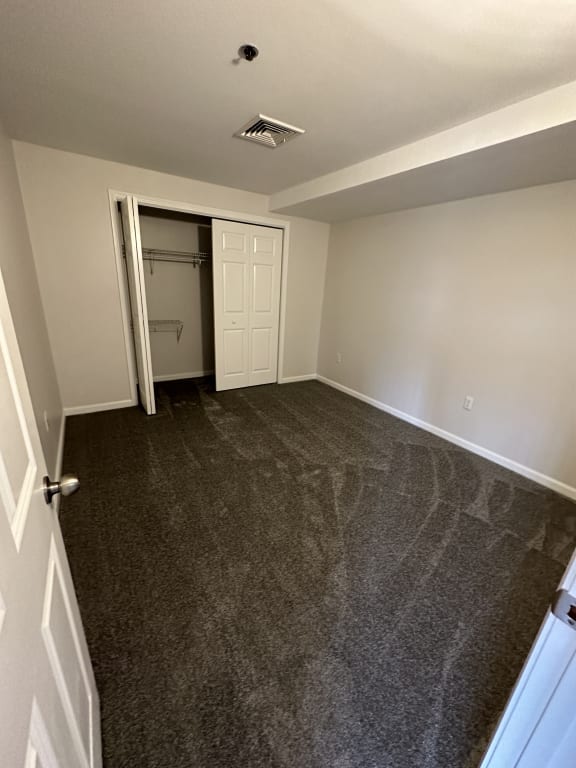 a room with a carpeted floor and a door to a closet at Carisbrooke at Manchester Apartments, Manchester, 03102