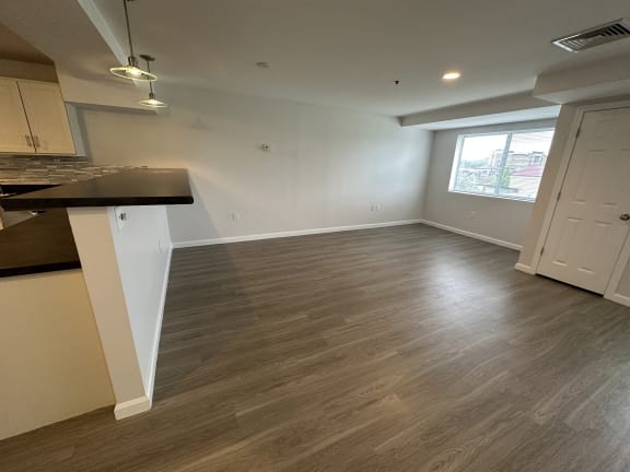 a kitchen and living room with wood flooring and a window at Carisbrooke at Manchester Apartments, Manchester