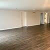 an empty living room with white walls and wood floors at Carisbrooke at Manchester Apartments, Manchester, NH
