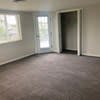 a living room with a carpeted floor and a door at Carisbrooke at Manchester Apartments, New Hampshire, 03102