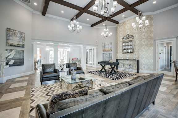 A large, modern living room with a dark leather couch and a fireplace.at Century Ariva, Florida