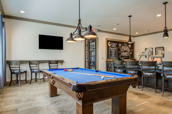 a game room with a pool table and a bar with a chalkboard