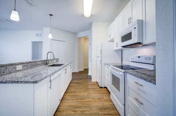 a kitchen with white cabinetry and granite countertops