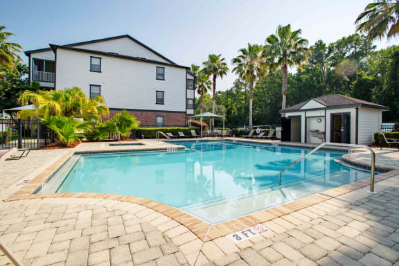 a swimming pool with a house and palm trees