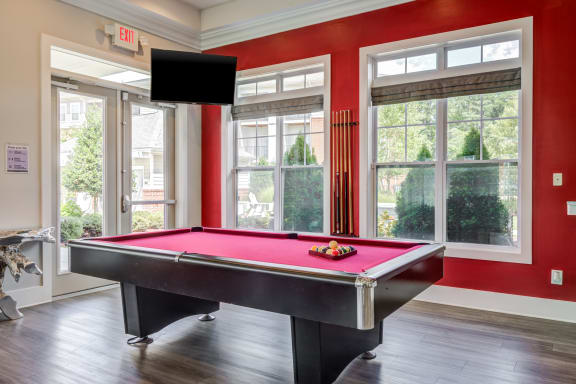 a pool table with a tv hanging above it