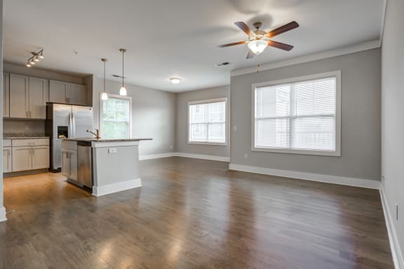 an empty kitchen and living room with a ceiling fan