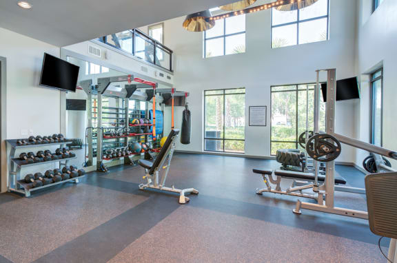 a gym with weights and other equipment and windows