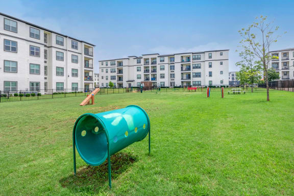 a green park with an apartment building in the background