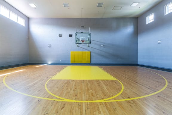 a basketball court in a large room with a yellow floor