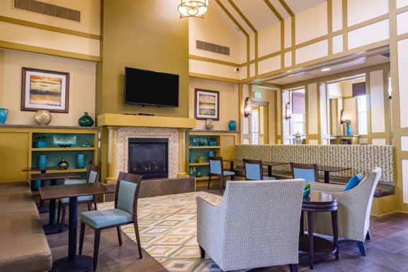 a lobby with tables and chairs and a fireplace