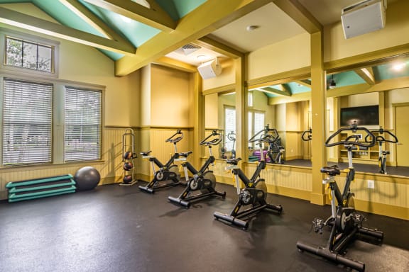 a gym with exercise bikes and weights on the floor