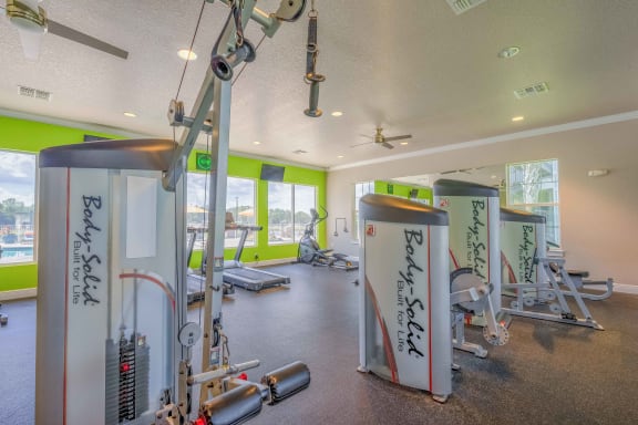 a gym with weights and exercise equipment at the enclave at university heights