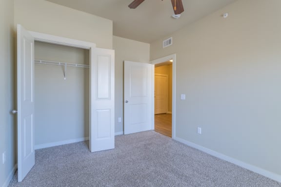 an empty bedroom with a closet and a ceiling fan  at Century Palm Bluff, Portland
