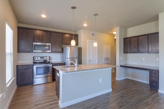an open kitchen with a large island and stainless steel appliances at Century Palm Bluff, Portland, 78374
