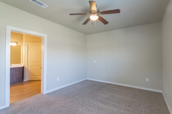 an empty room with a ceiling fan and a door to a bathroom at Century Palm Bluff, Portland, TX