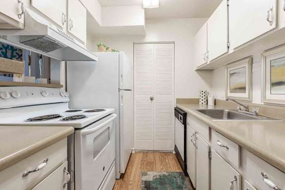 A kitchen with white appliances and cabinets.