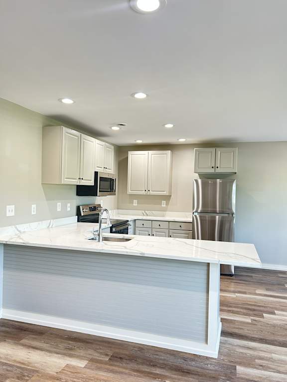 A kitchen with a white counter top and wooden floors at Briarcliff at Quechee, Quechee, VT, 5059