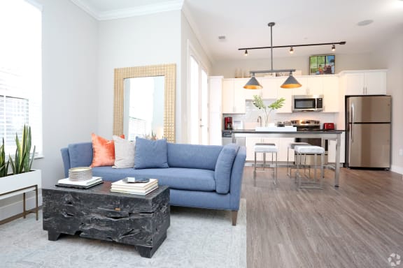 a living room and kitchen with a blue couch and a table at Century Baxter Avenue, Louisville Kentucky