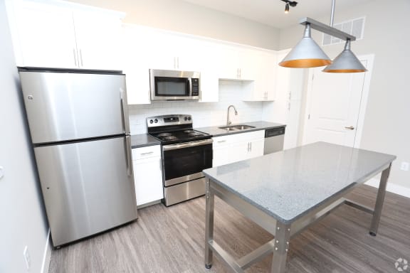 a kitchen with stainless steel appliances and a table at Century Baxter Avenue, Louisville, 40204