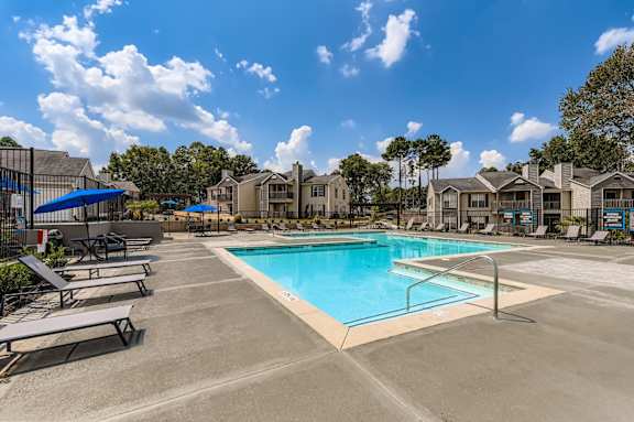 A swimming pool surrounded by sun loungers and apartment buildings at Keita 1875, Georgia 30349