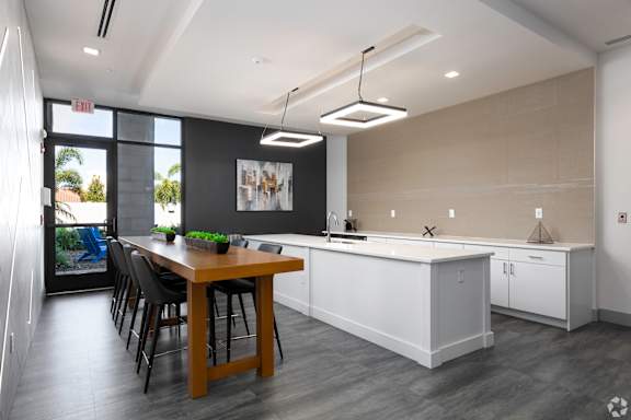 A modern kitchen with a dining table and chairs.