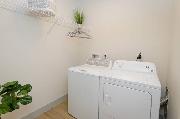 A white washing machine and dryer in a small laundry room.