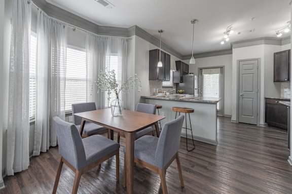 a dining room and kitchen with a table and chairs
