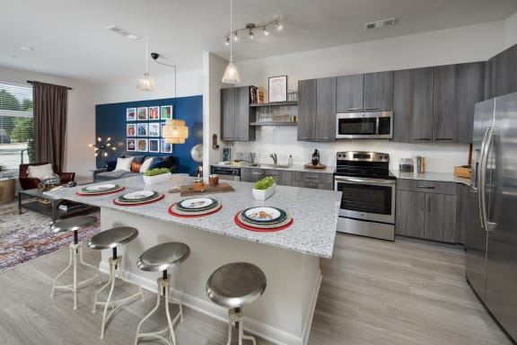 a kitchen with a large island with a breakfast bar and stainless steel appliances at Marley EAV, Atlanta
