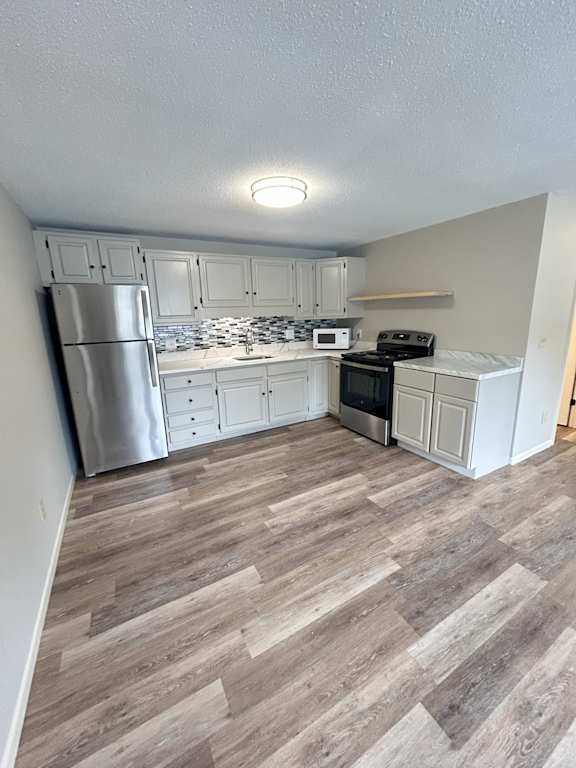 Floor Plan  A kitchen with a refrigerator, microwave, oven, and cabinets. at Briarcliff at Quechee, Quechee, 05059