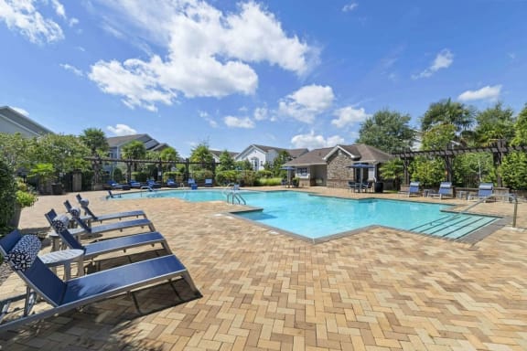 a resort style pool with lounge chairs around it at Century HomePlace, Prattville