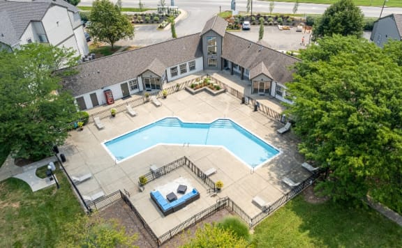 an aerial view of a swimming pool in front of a house