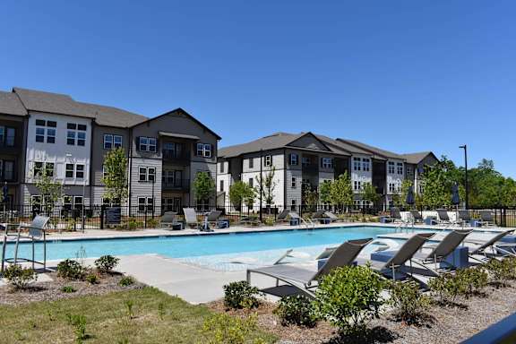 our apartments have a large swimming pool with lounge chairs at Century Mundy Mill Apartments, Oakwood, GA 30566