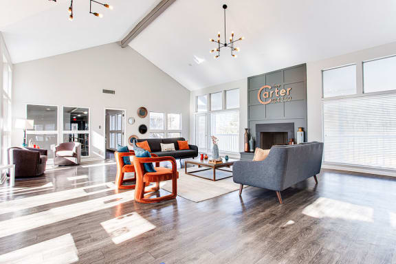 A living room with a grey couch and a fireplace at The Carter 4250 Apartments, Georgia 30093