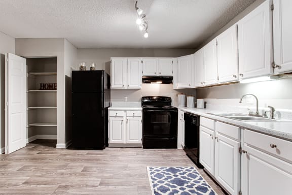 an updated kitchen with white cabinets and black appliances at The Lory of Harbison in Columbia, SC
