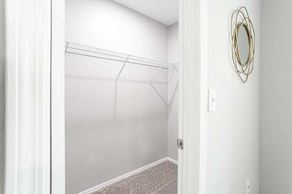 a walk in closet with white walls and a mirrored closet door at Keita 1875, Georgia 30349