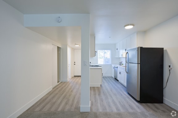 a kitchen with white cabinets and a black refrigerator