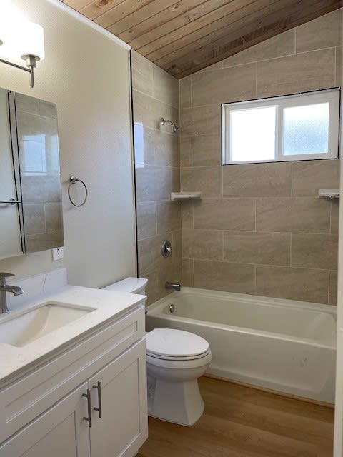 a bathroom with a toilet and a tub and a sink