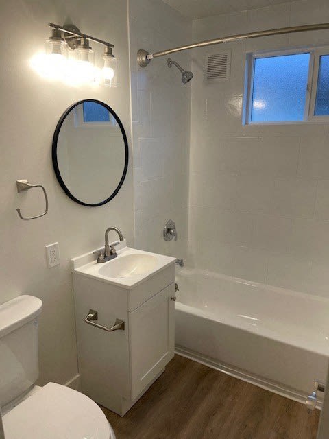 a white bathroom with a sink and a bath tub