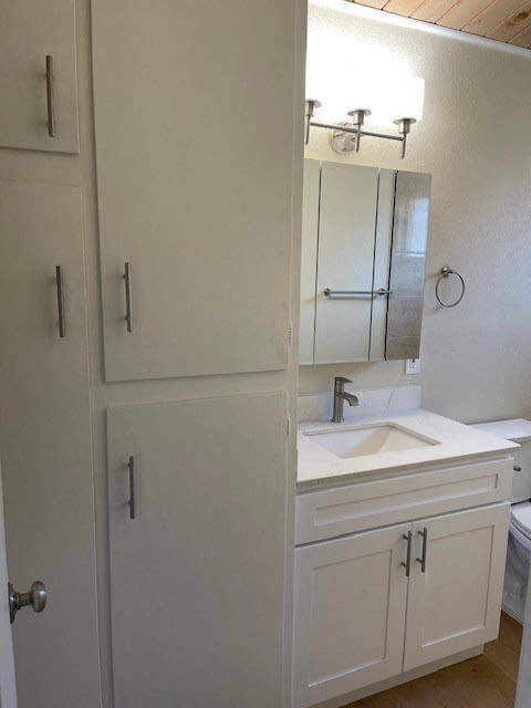 a white bathroom with a sink and a mirror