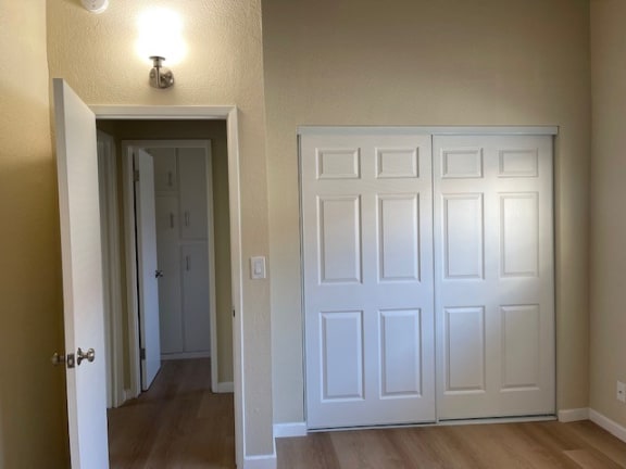 an empty room with a white door and a hallway