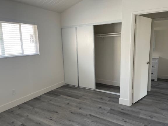 an empty bedroom with a closet and a window
