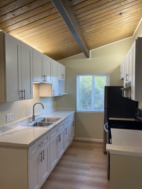 a kitchen with white cabinets and a sink