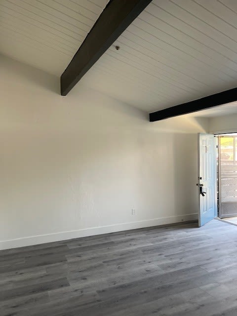 an empty room with white walls and a blue door