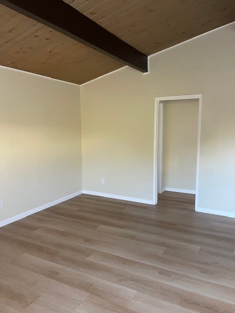 an empty room with a wooden floor and a door