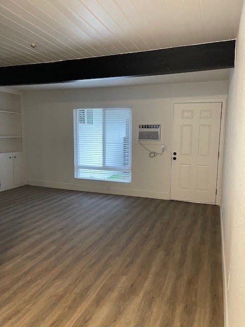 an empty living room with a door and a window