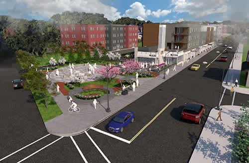 A street view of a city with cars, a pedestrian crossing and a roundabout.